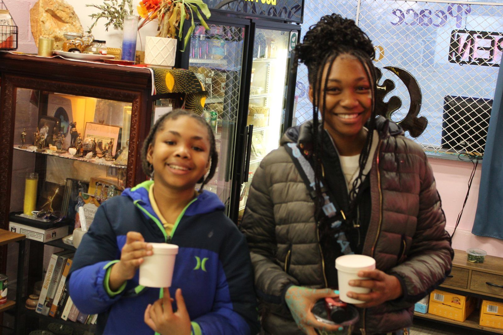 Two smiling Snack Squad kids holding their Friday cups inside Peace of Mine