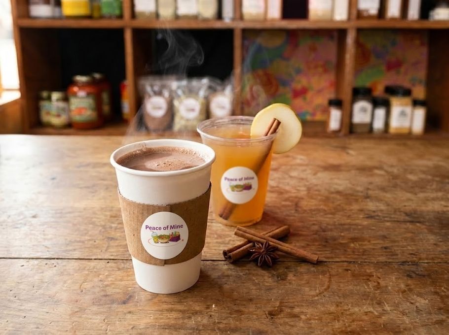 A steaming hot cocoa and a warm pear cider with a cinnamon stick on the Peace of Mine counter